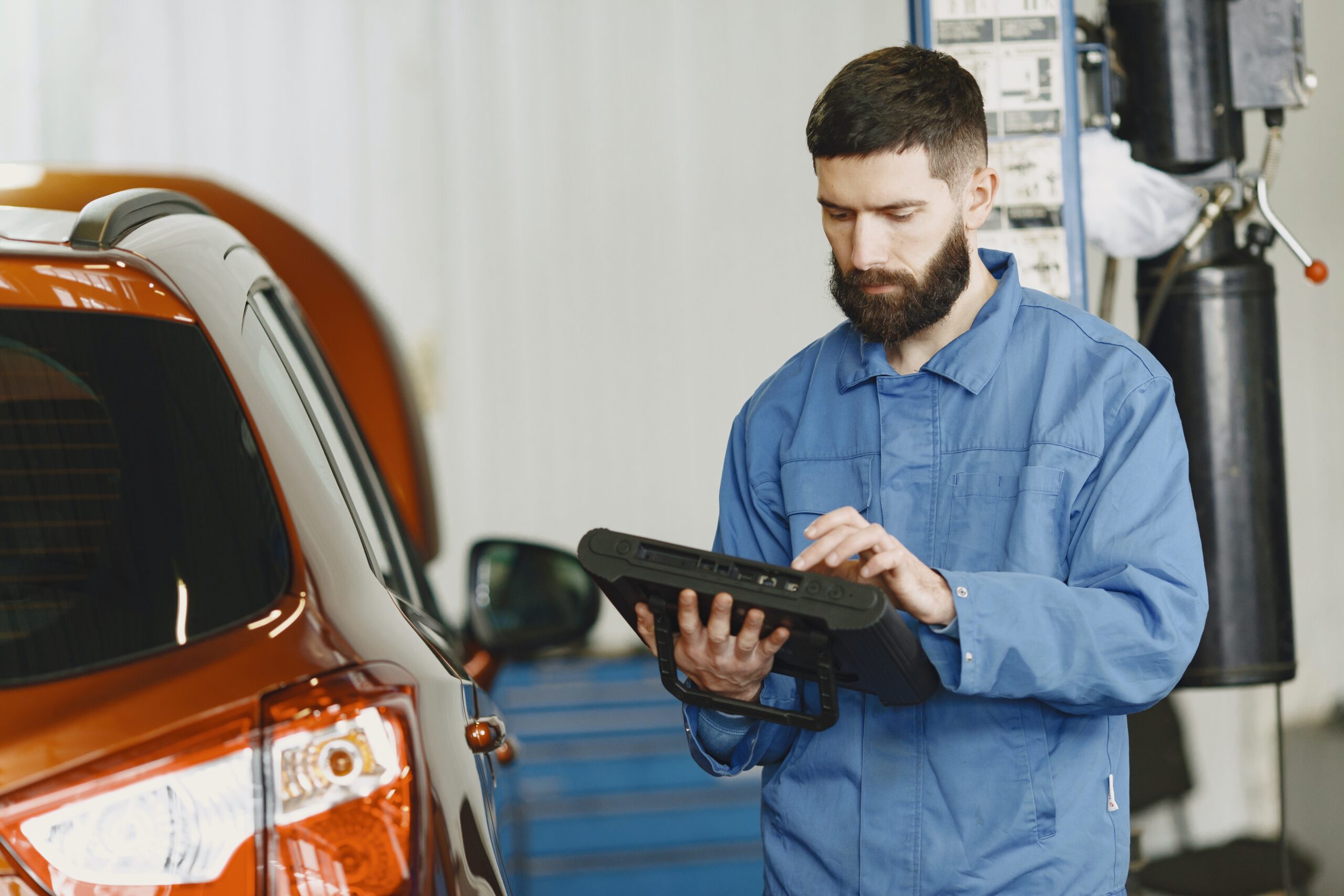 Auto technician checking tablet in auto shop